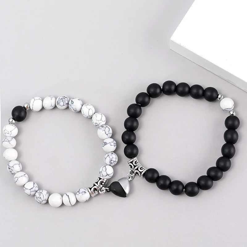 Par de pulseras para pareja blanco y negro con corazón imantado